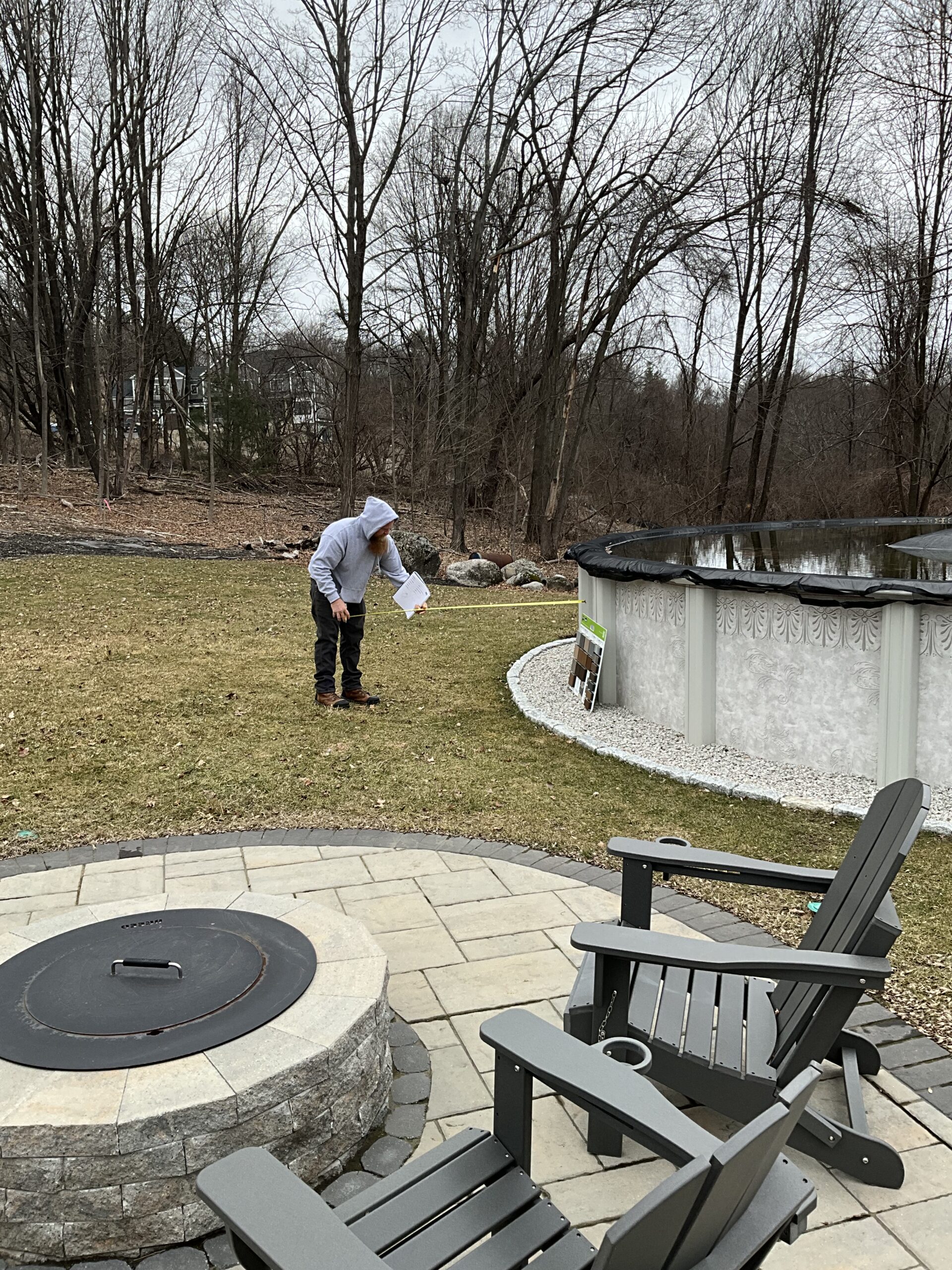 contractor measuring for a deck around an above ground pool
