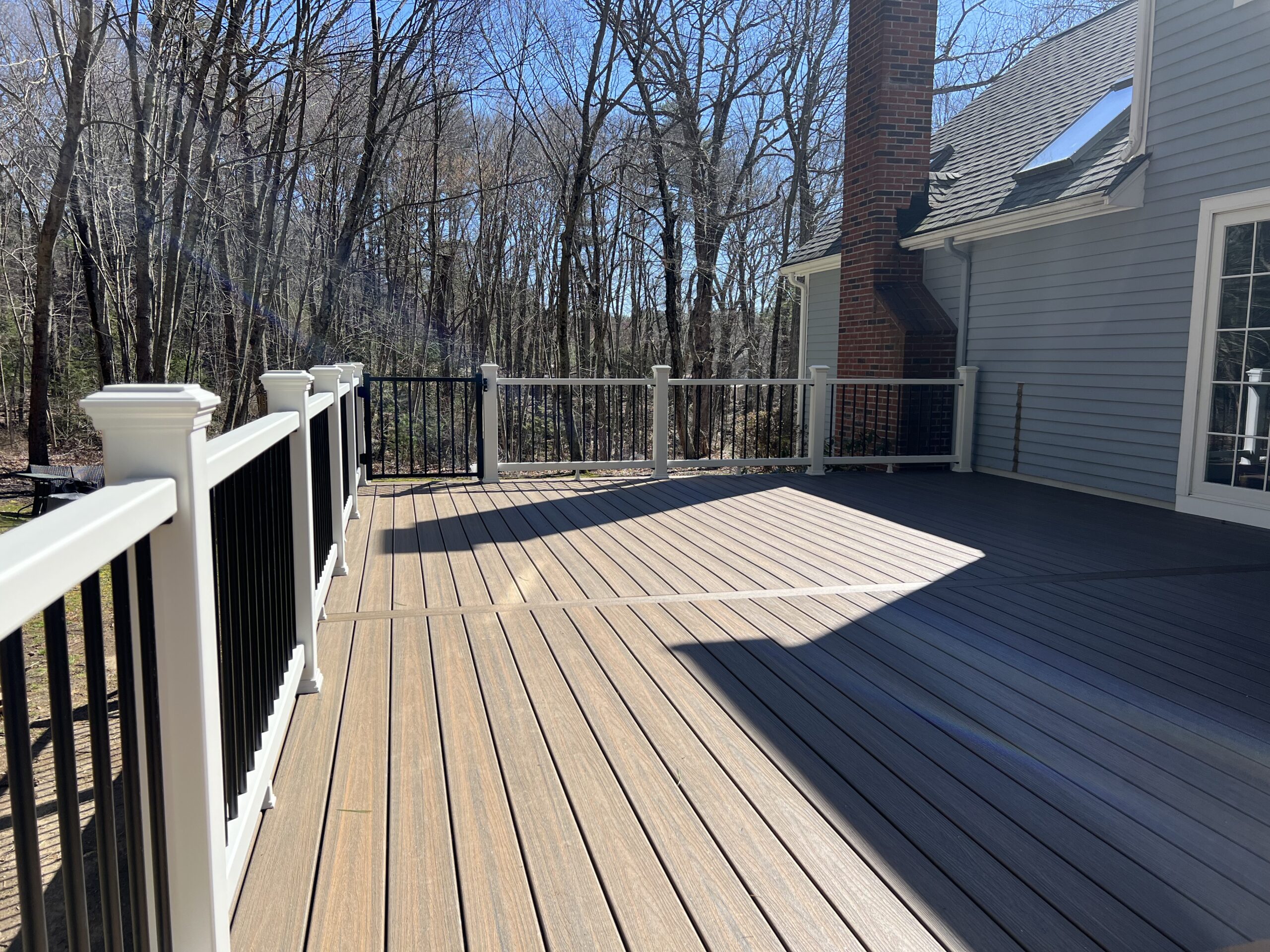 Trex deck with Toasted sand decking and white r railings. Upton MA Deck